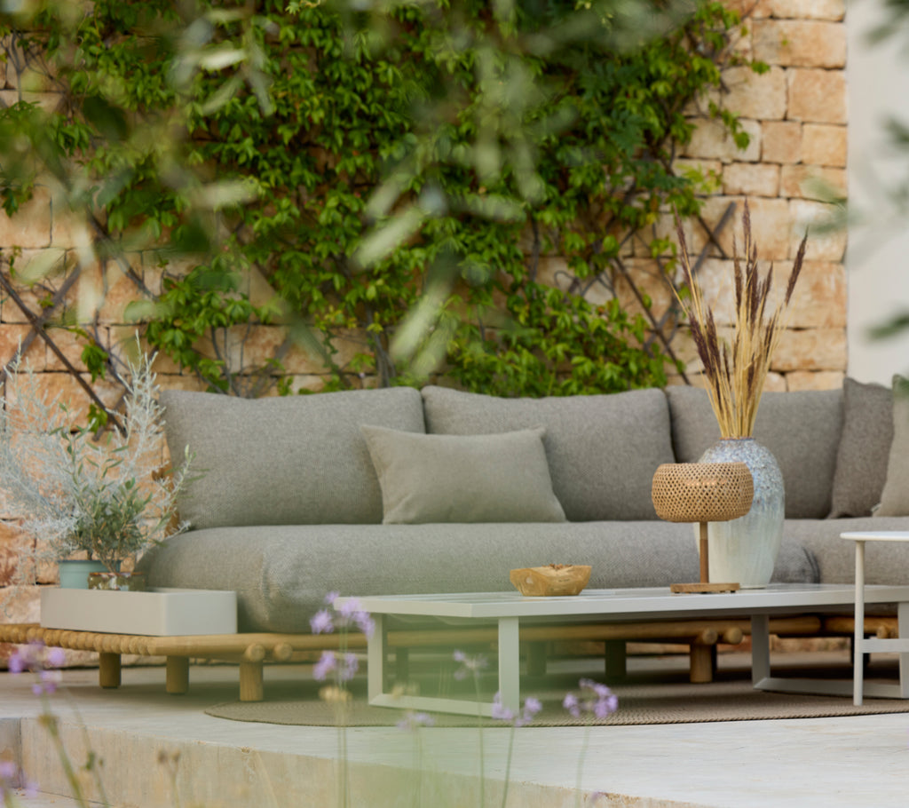 Moderne grijze bank met een houten tafel in een stijlvolle buitenlounge.