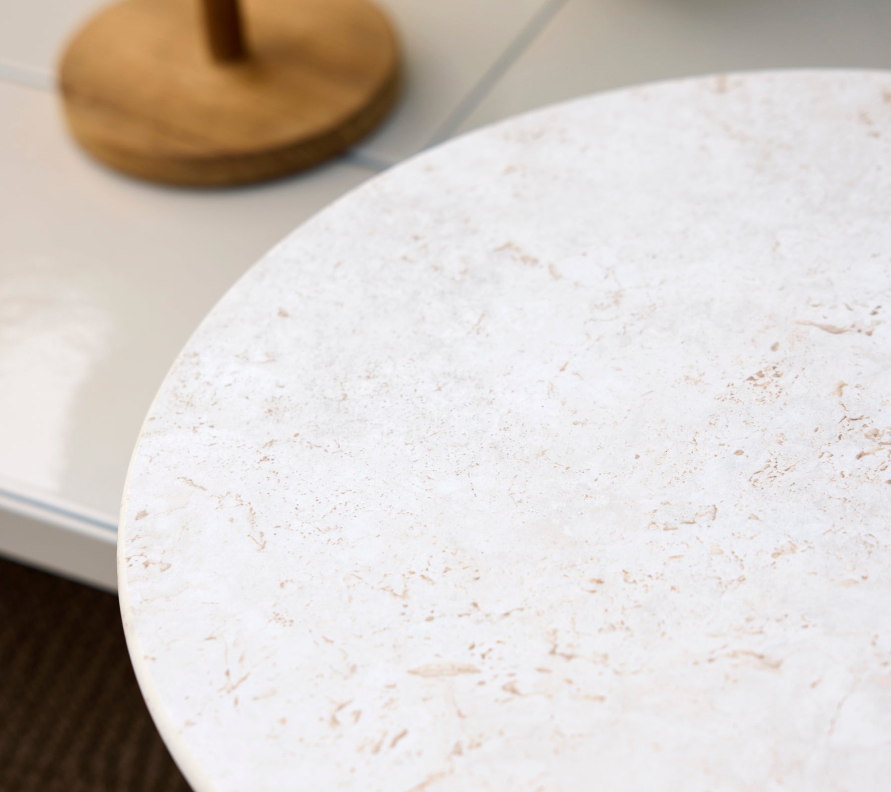 Ronde witte tafelblad met een lichte textuur.