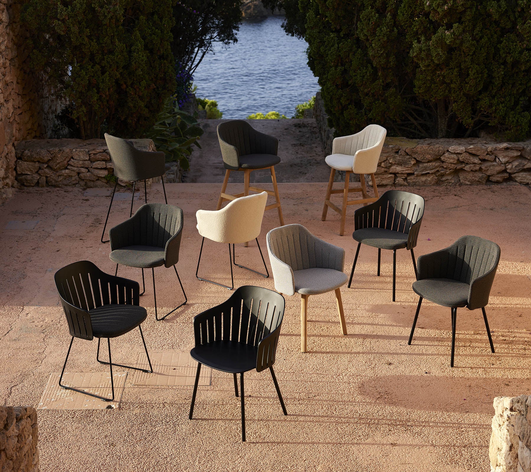 Een collectie stijlvolle stoelen in verschillende kleuren, gerangschikt in een schilderachtige setting, die veelzijdige ontwerpkeuzes toont.
